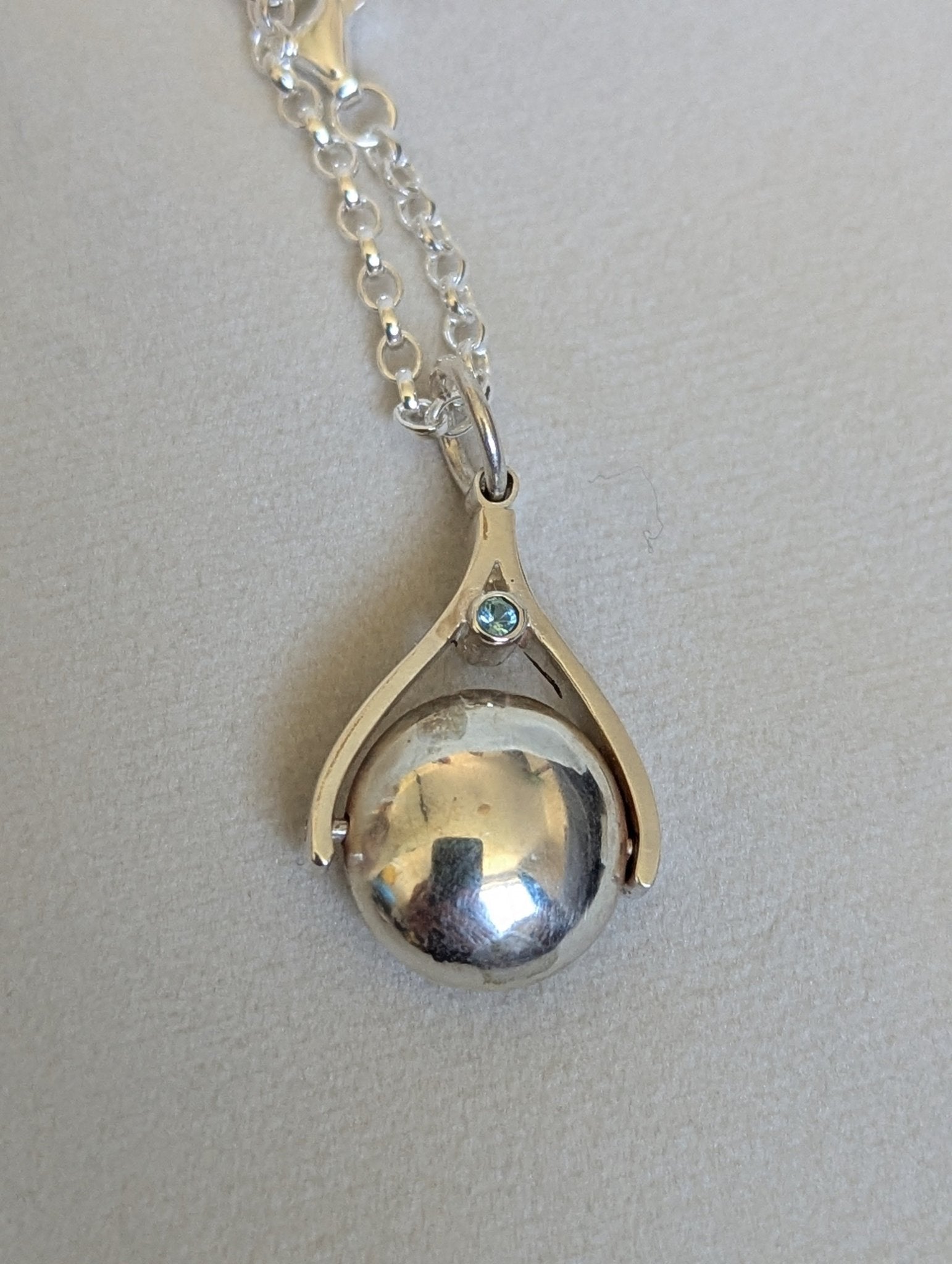 Detail of Silver Spinning Pendant Necklace with Sky Blue Topaz made by Booblinka Jewellery