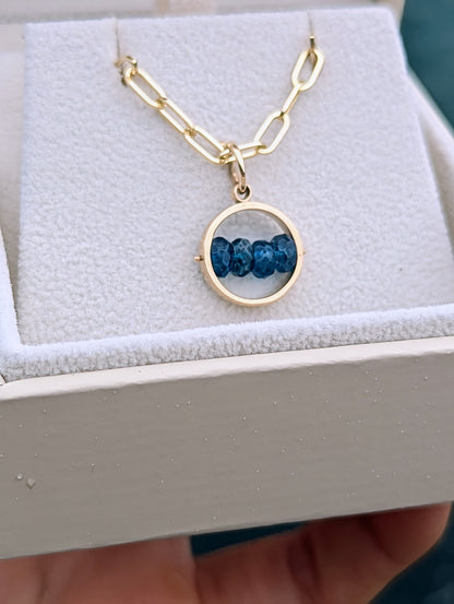 9ct gold blue topaz HALO pendant with four deep blue gemstones, shown on its solid gold paperclip chain in a jewellery box.
