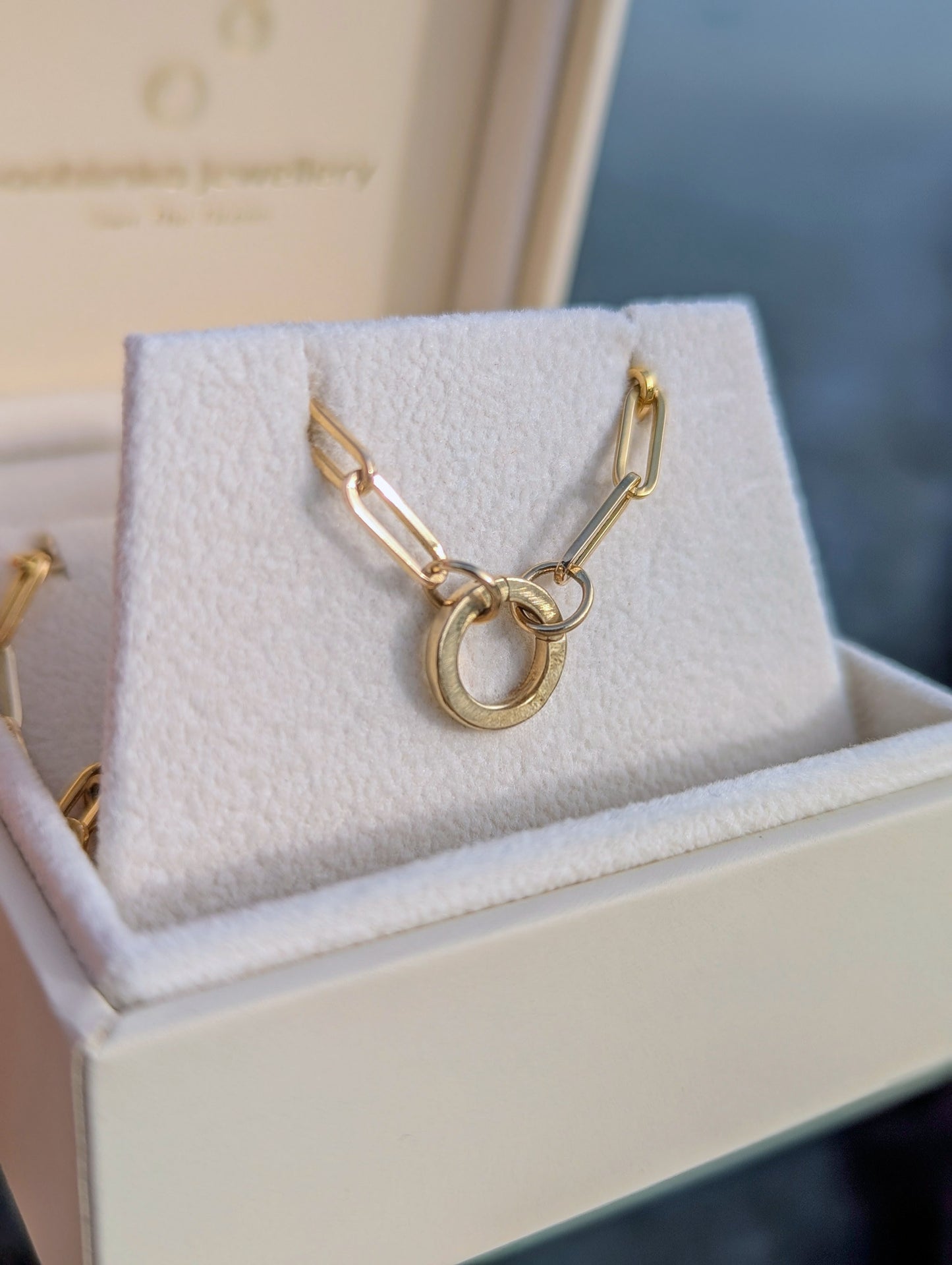 Gold paperclip necklace with a unique design hinged round connector in a jewellery box made by Booblinka Jewellery.