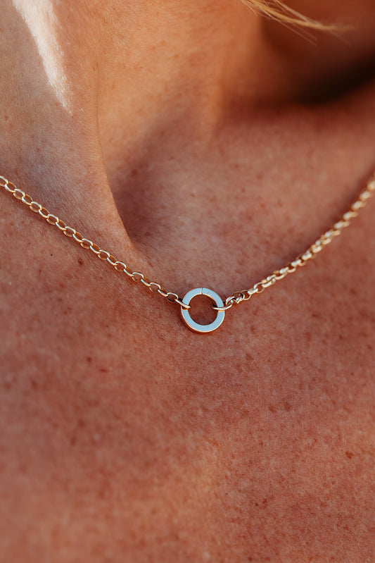 Gold necklace with a circular pendant on a person's neck made by Booblinka Jewellery