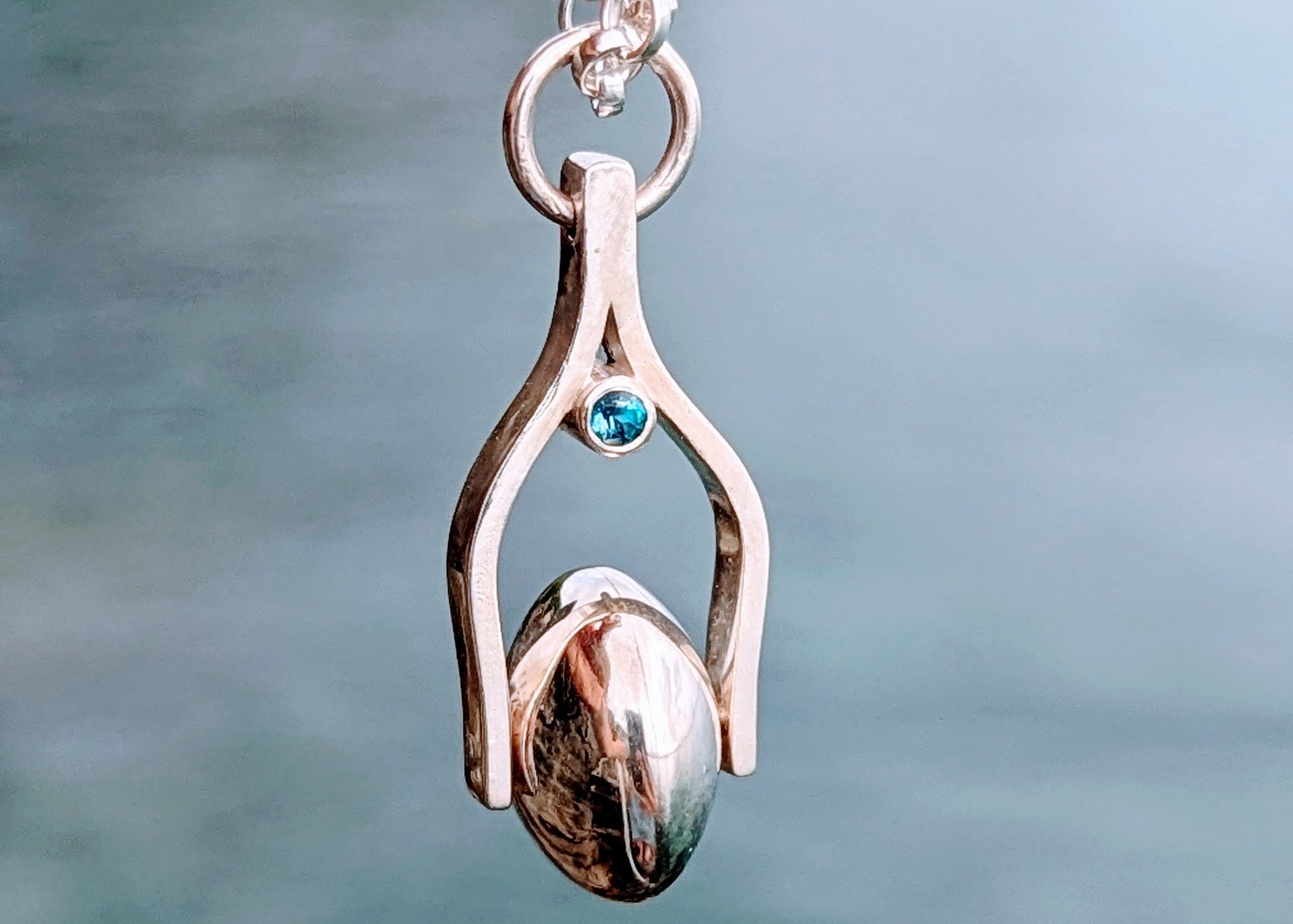 Silver spinning moon pendant with blue topaz made by Booblinka Jewellery