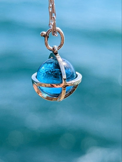 Detail of Blue topaz sphere with a shimmering ocean background made by Booblinka Jewellery