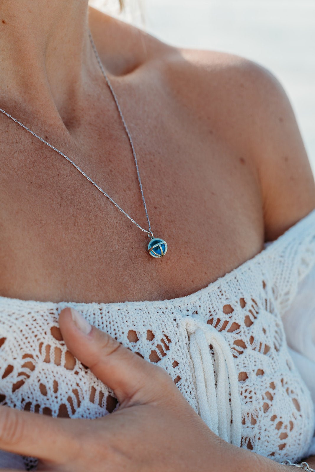 Model wearing Drop of the Ocean Necklace - Fairtrade 9 Carat White Gold & Swiss Blue Topaz Sphere Necklace by Booblinka Jewellery