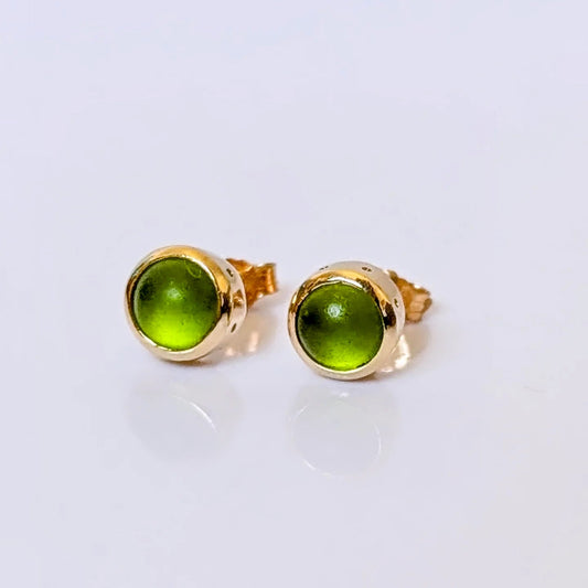Green sea glass stud earrings handmade in solid 9ct gold, shown together on a pale background.