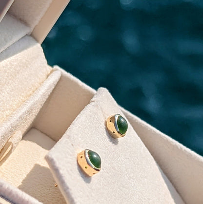 Angled view of green sea glass stud earrings in 9ct gold, showing the handmade bubble detail around the settings.