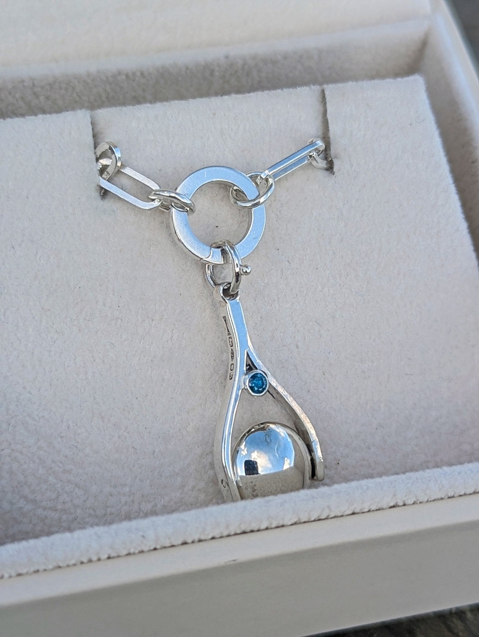 Mini Minstrel Spinning Necklace in Sterling Silver with Blue Diamonds on a paperclip chain in an ivory jewellery box made by Booblinka Jewellery