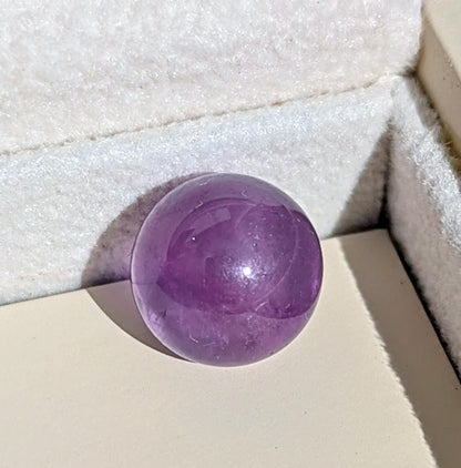 Close-up of the smooth purple Amethyst sphere available to choose for the silver ORB necklace