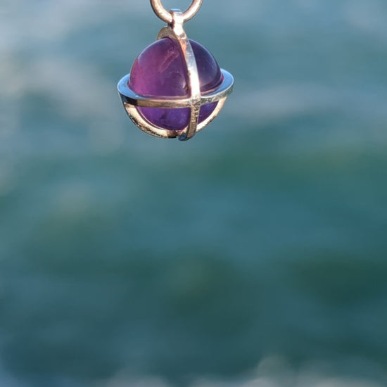 Amethyst sphere silver necklace above the ocean video