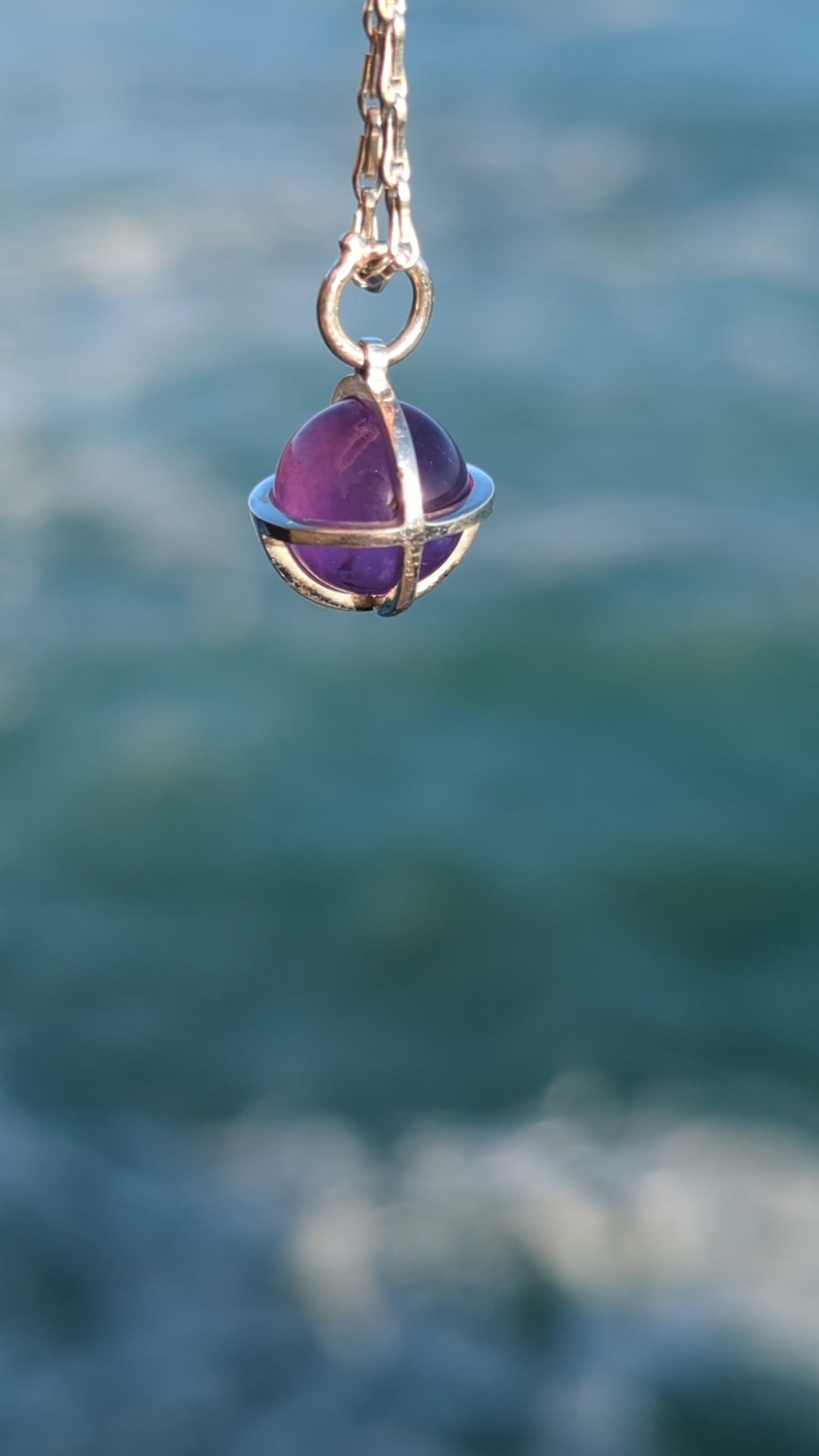 Amethyst sphere silver necklace above the ocean video