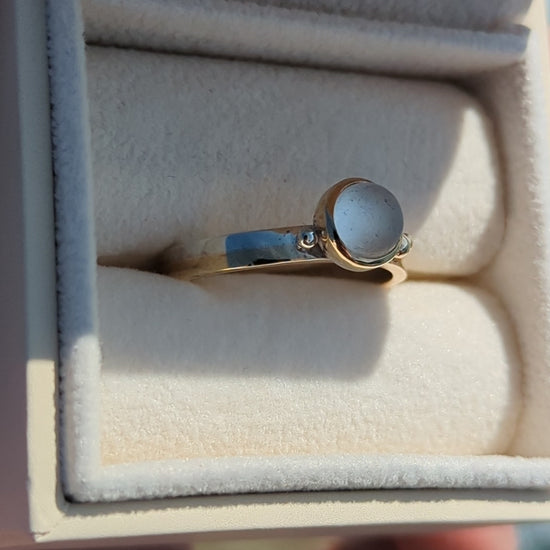Video of Handmade Gold and silver ring with a white sea glass in a jewellery box against shimmering ocean made by Booblinka Jewellery