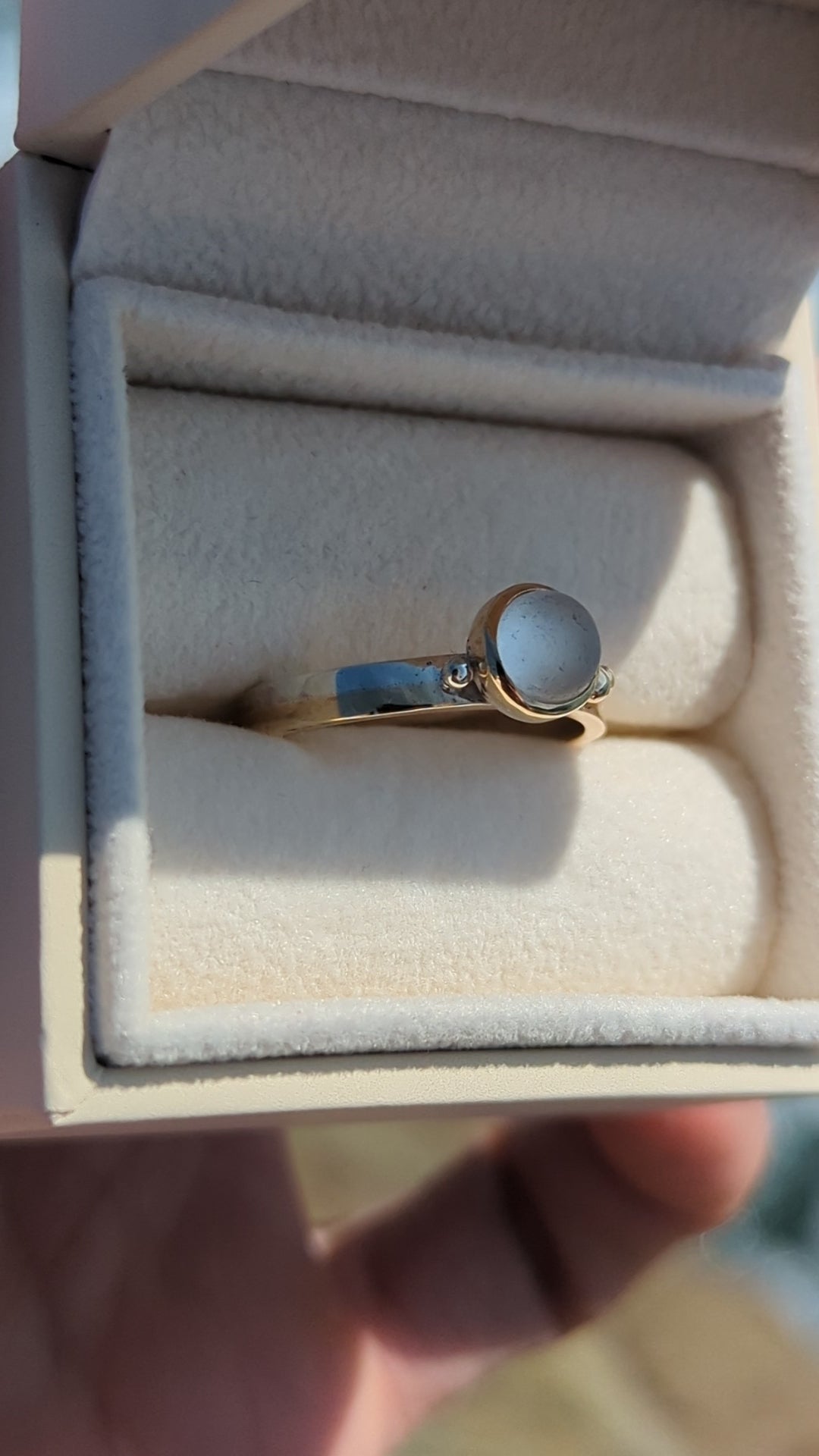 Video of Handmade Gold and silver ring with a white sea glass in a jewellery box against shimmering ocean made by Booblinka Jewellery