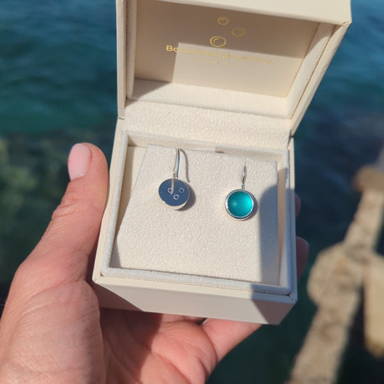 Video of Teal Sea Glass Drop Earrings in Sterling Silver in a jewellery box above the ocean made by Booblinka Jewellery