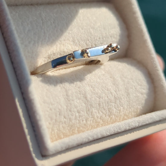 Contemporary Silver Ring with 9ct Gold Granules in an ivory jewellery box above the ocean made by Booblinka jewellery