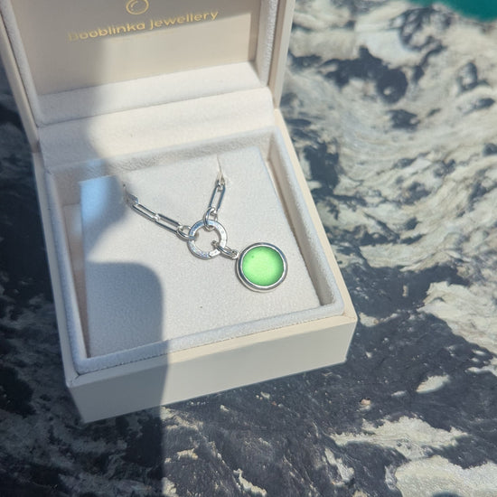Video showing how to open the hinged charm holder to remove the green sea glass pendant from the sterling silver paperclip chain.