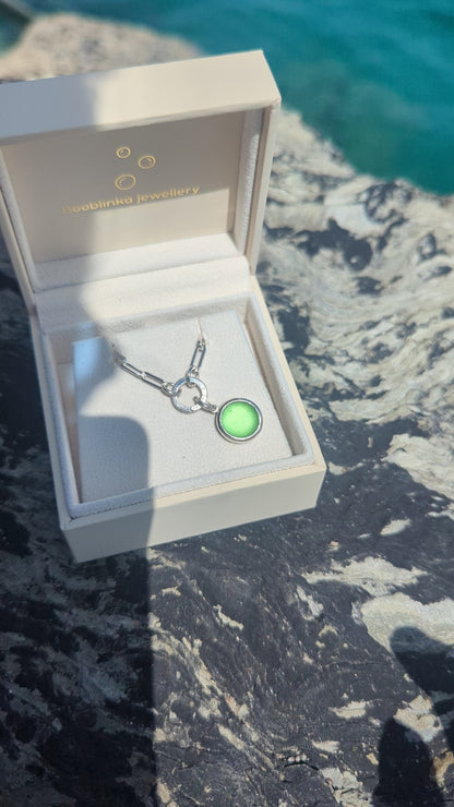 Video showing how to open the hinged charm holder to remove the green sea glass pendant from the sterling silver paperclip chain.