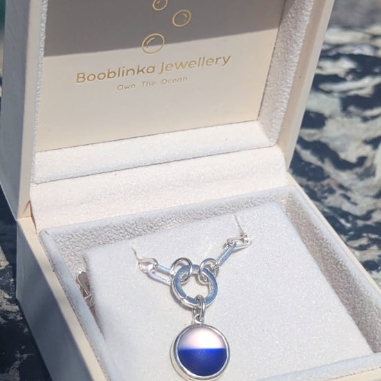 Video showing how to open the sterling silver hinged charm holder and attach the blue and white sea glass pendant to the chain.