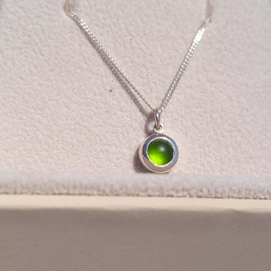 Video showing a tiny genuine green sea glass necklace in sterling silver from different angles and how it catches the light.