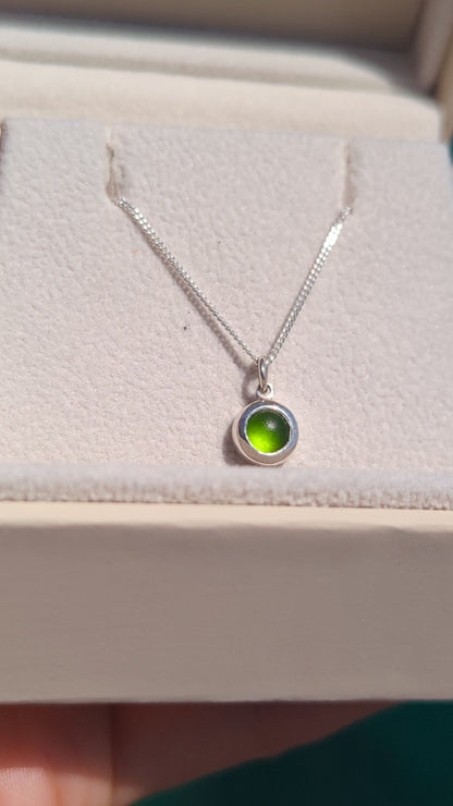 Video showing a tiny genuine green sea glass necklace in sterling silver from different angles and how it catches the light.