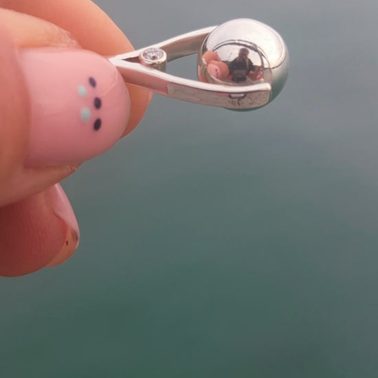 Video of a handmade mini silver spinning necklace with moissanites and spinning silver ball, one-off piece by Booblinka Jewellery.
