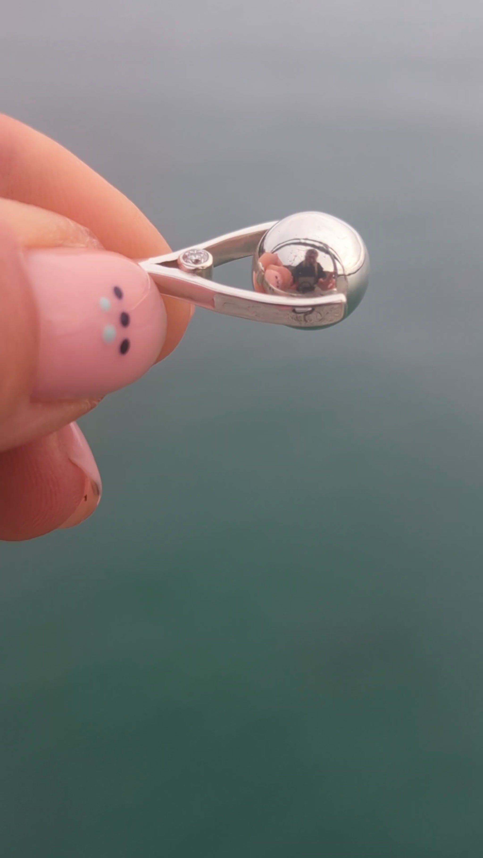 Video of a handmade mini silver spinning necklace with moissanites and spinning silver ball, one-off piece by Booblinka Jewellery.