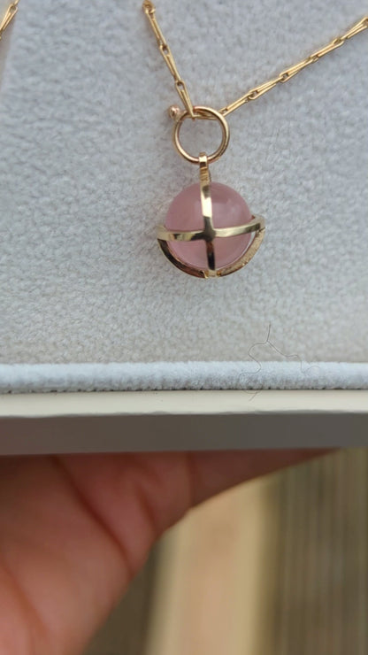 Video of spherical rose quartz set in solid gold cage in a jewellery box