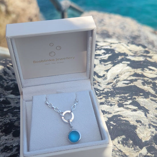 Video showing how to open the sterling silver hinged charm holder and remove the blue sea glass pendant from the necklace.