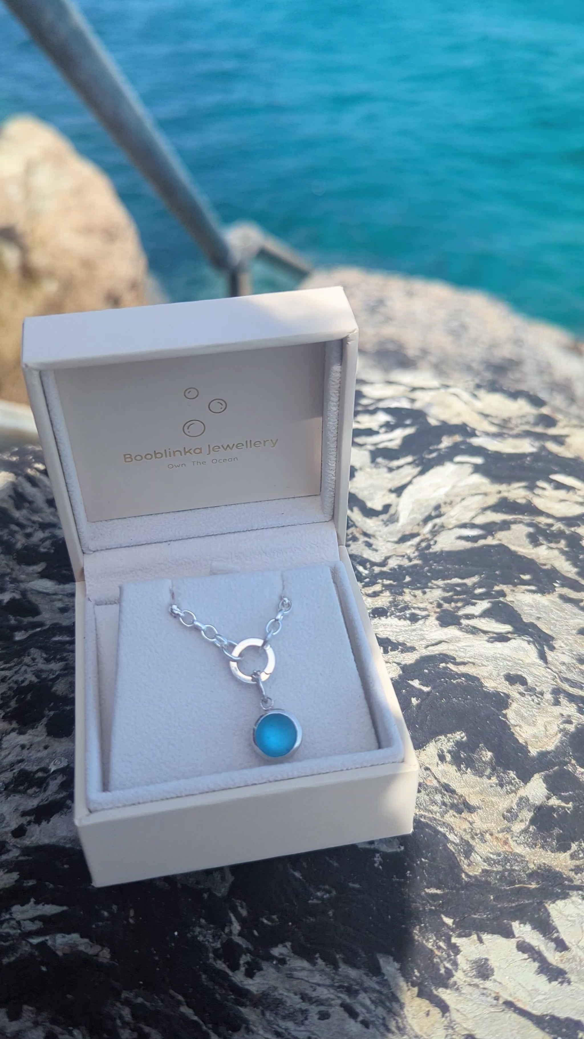 Video showing how to open the sterling silver hinged charm holder and remove the blue sea glass pendant from the necklace.