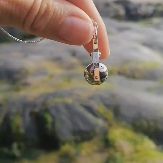 Video of the spinning moon necklace in sterling silver with a blue gemstone, showcasing its unique design as seen in 'Playing Nice' by Booblinka Jewellery 
