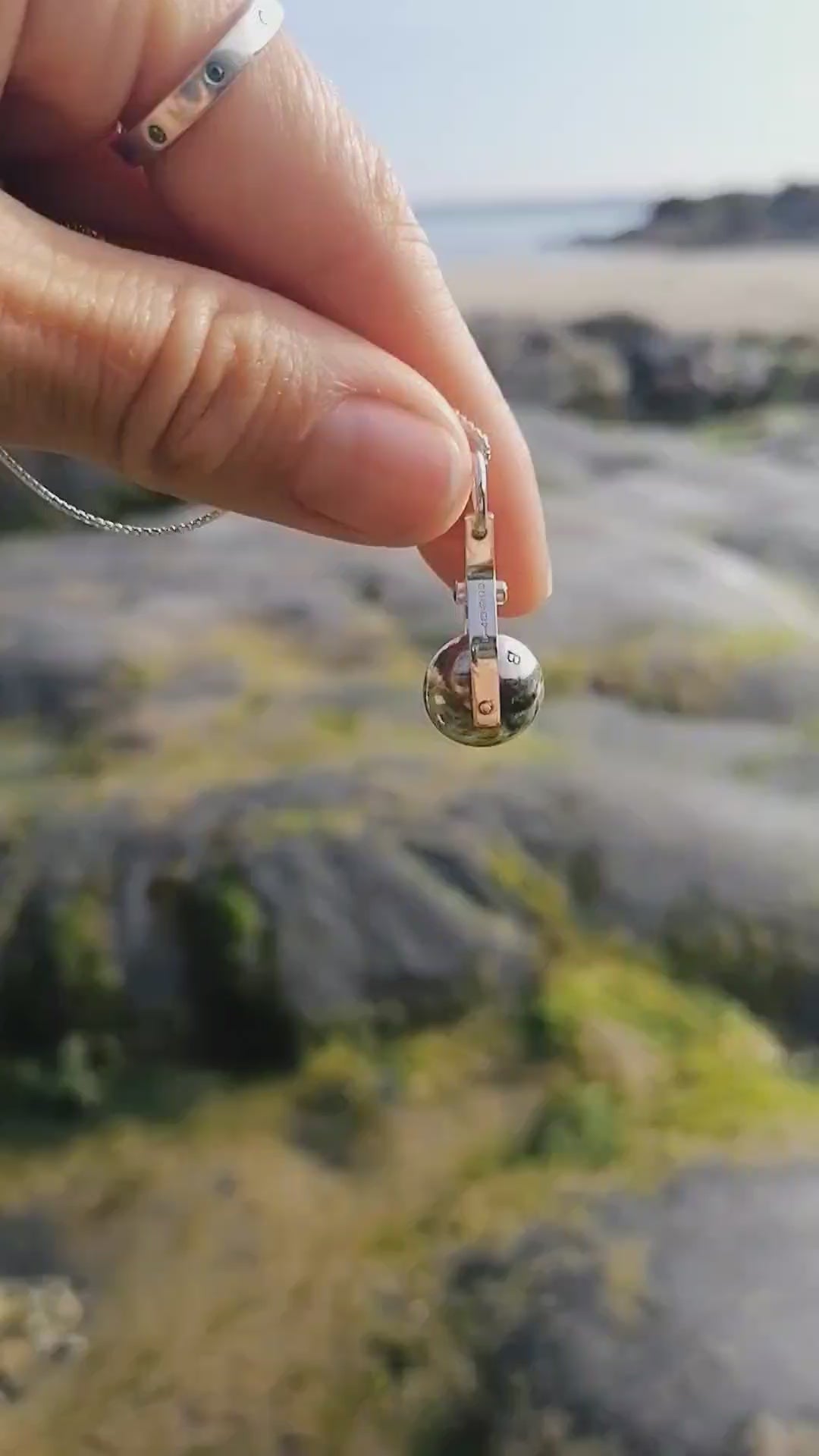 Video of the spinning moon necklace in sterling silver with a blue gemstone, showcasing its unique design as seen in 'Playing Nice' by Booblinka Jewellery 