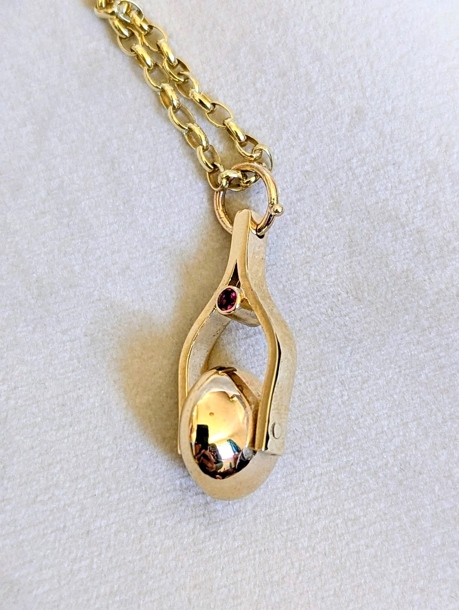 Gold Spinning Moon Necklace with pink tourmalines made by Booblinka Jewellery on a light velvet background