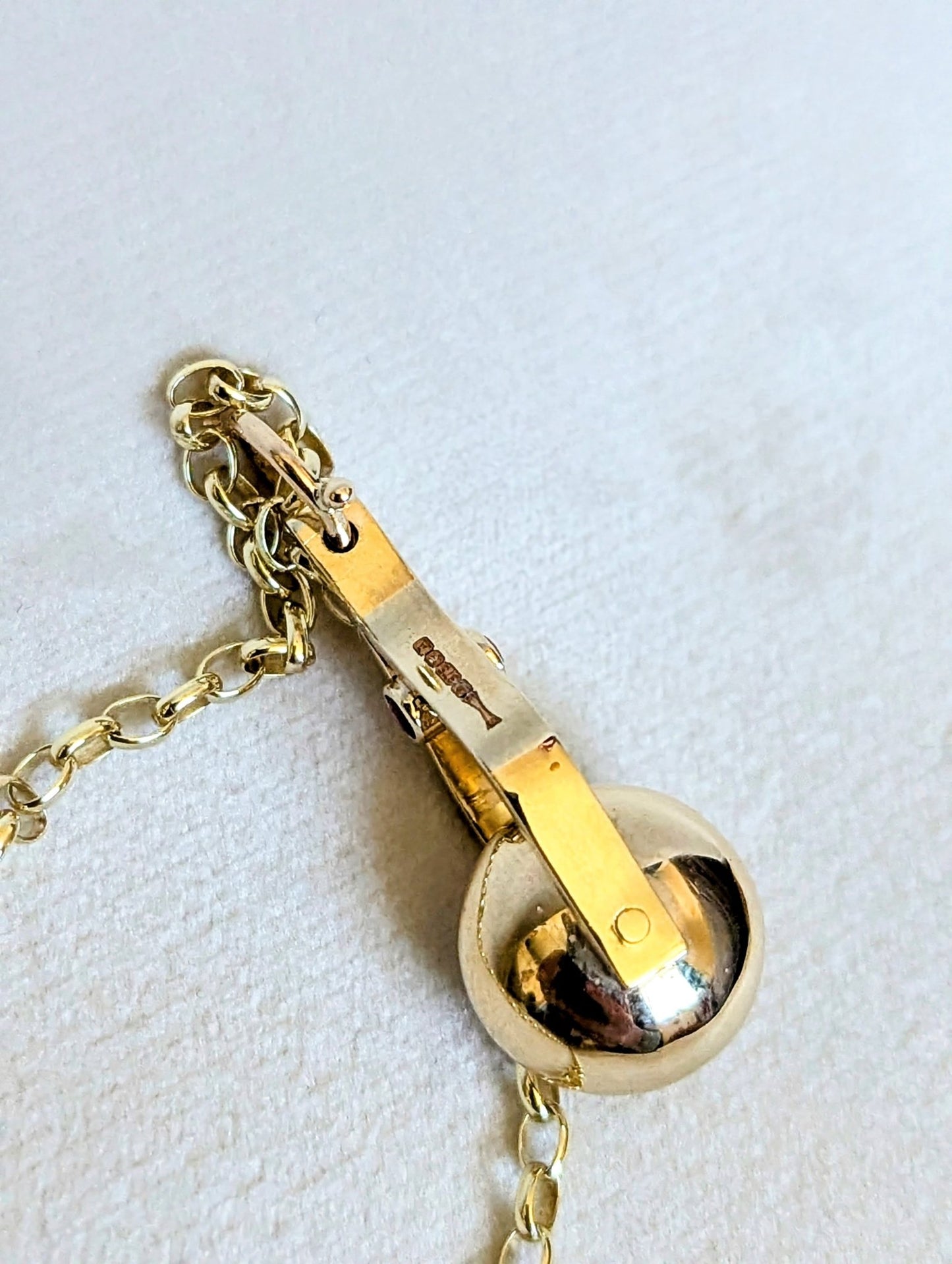 Hallmark detail on a Gold Spinning Moon Necklace with pink tourmalines made by Booblinka Jewellery