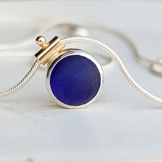 Silver and gold snake necklace with deep blue round sea glass