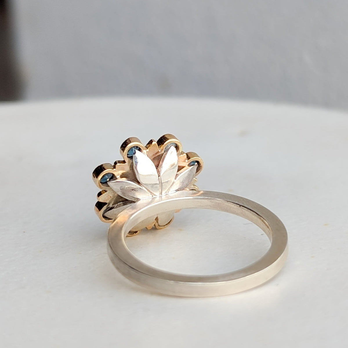 Side view of the gold flower setting and sterling silver ring band.